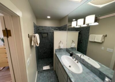 Bathroom with gray tiles, a sink, and shower