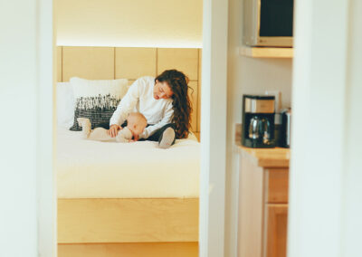 Woman with happy baby on queen bed